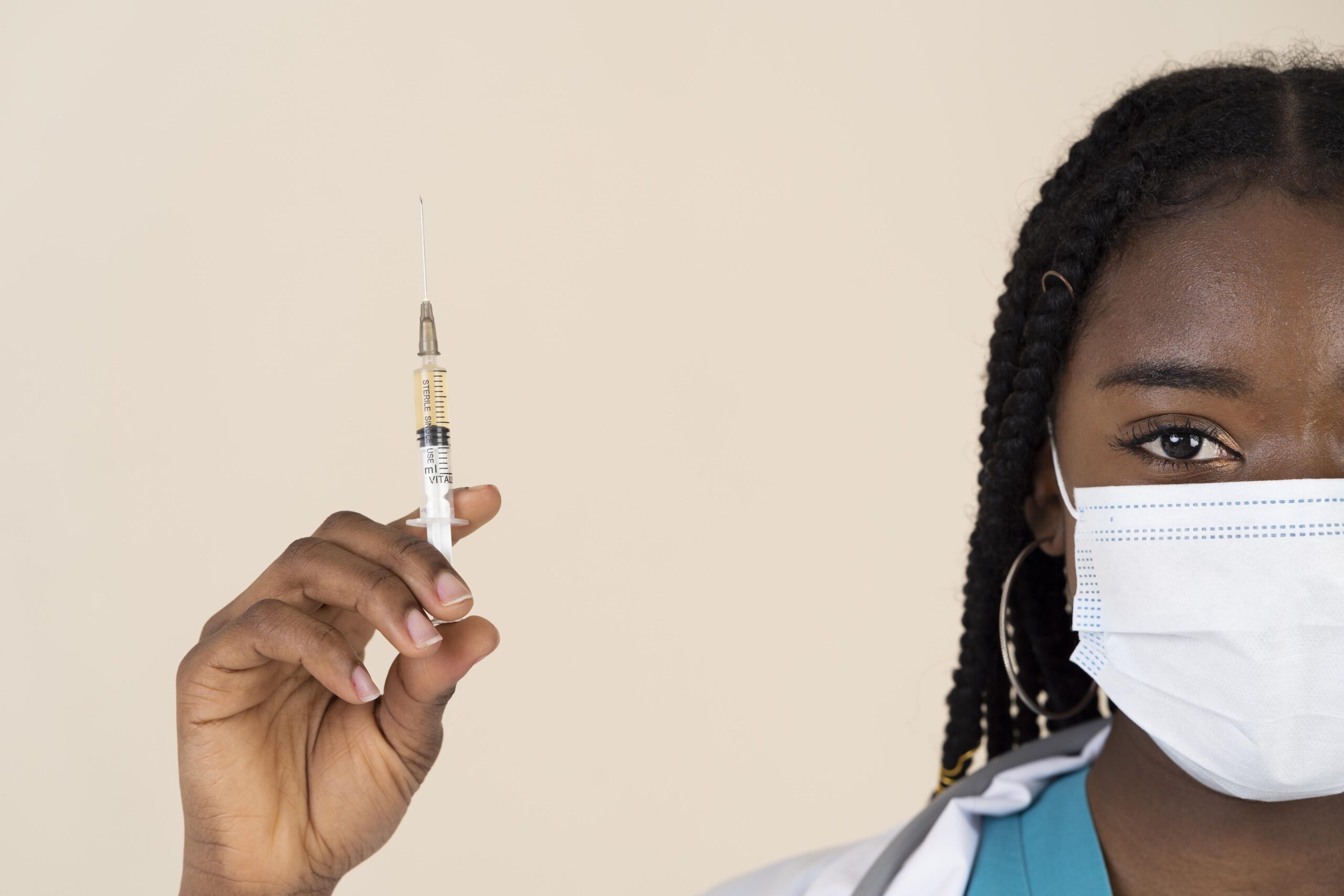 female doctor holding syringe with vaccine